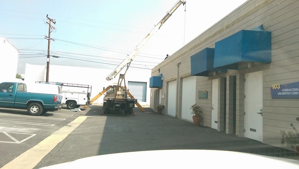 A blue truck is parked in front of a building