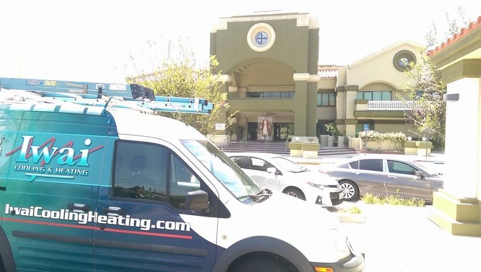 A blue and white van is parked in front of a building.