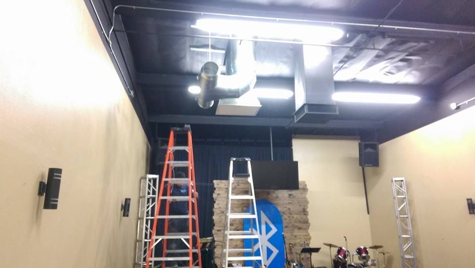 A room with a ladder and a drum set in it