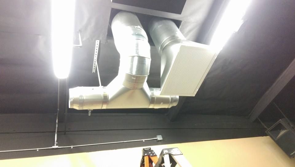 A ceiling with a bunch of pipes hanging from it