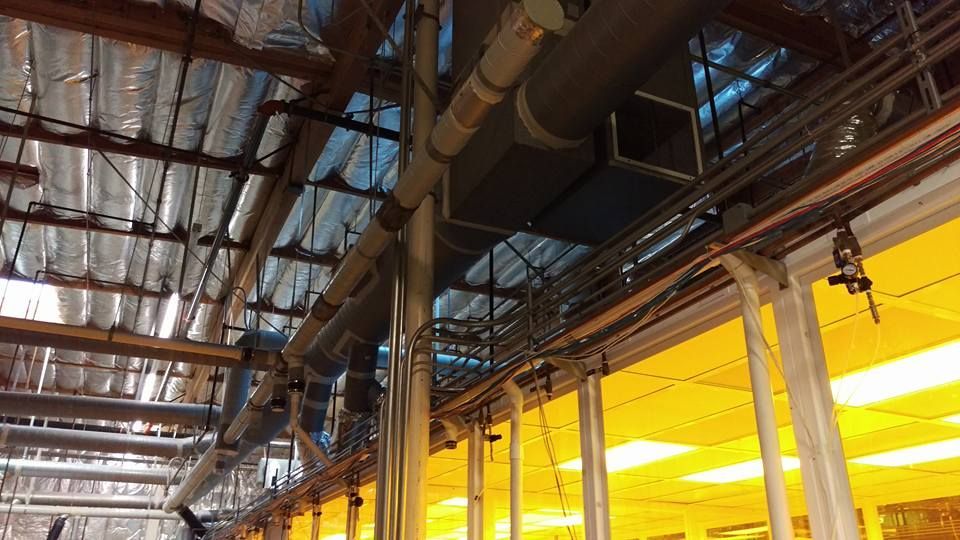 A large room with a lot of pipes hanging from the ceiling.