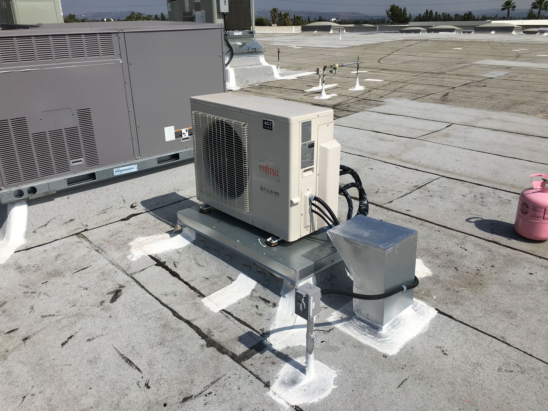 An air conditioner is sitting on the roof of a building.