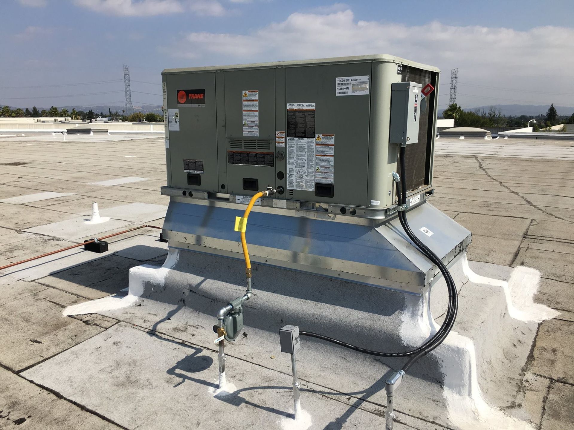 An air conditioner is sitting on top of a roof.