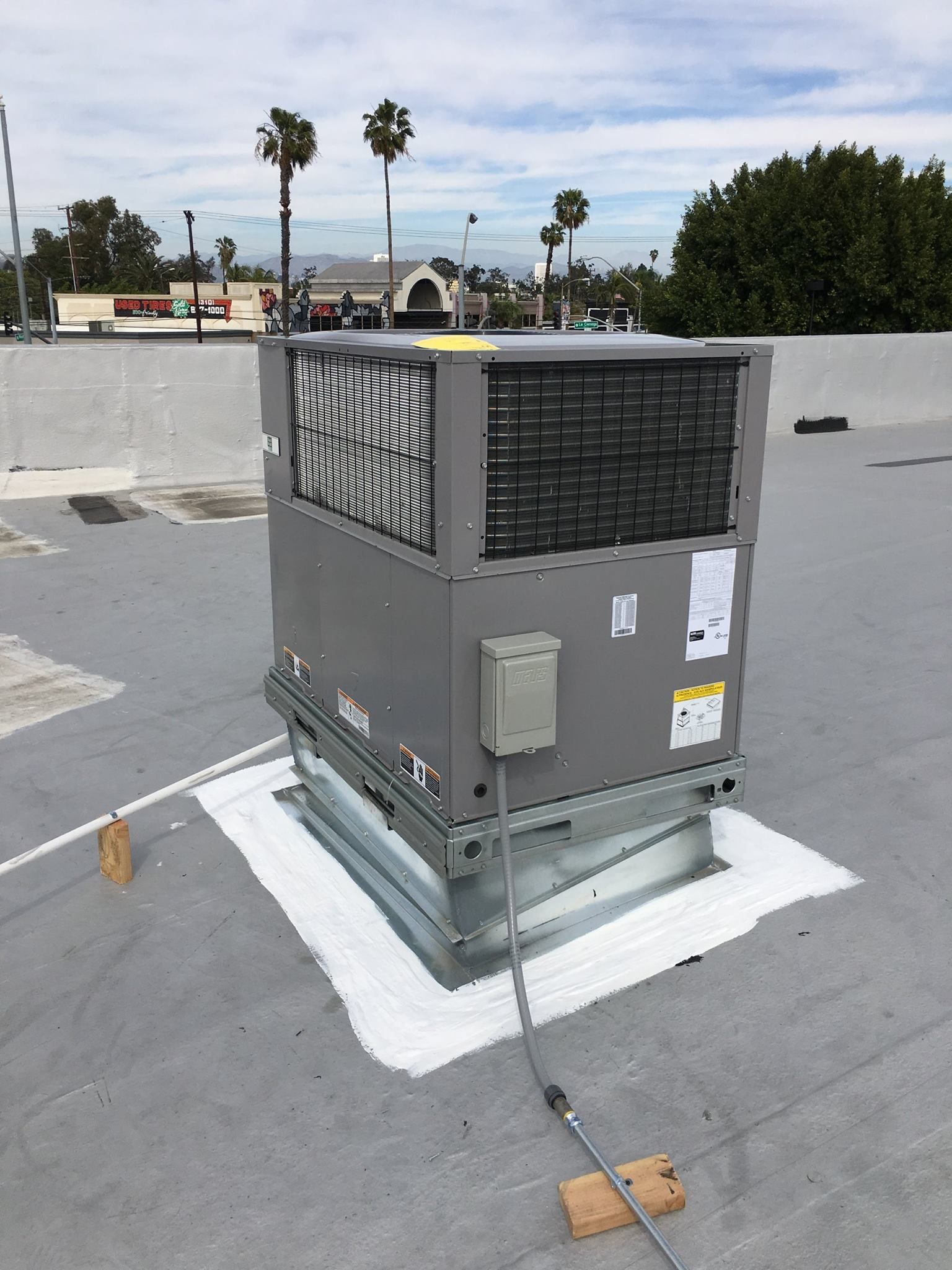 A large air conditioner is sitting on top of a roof.