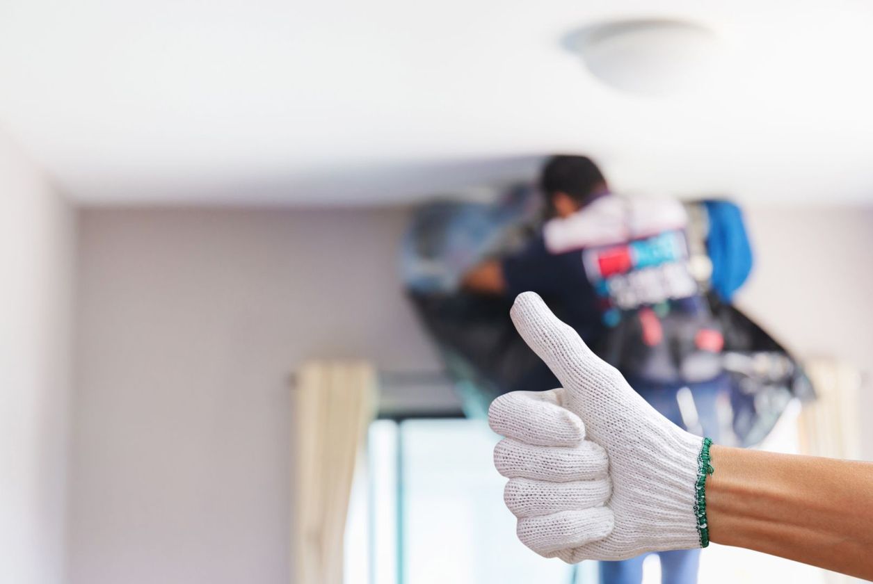 A person wearing a white glove is giving a thumbs up.