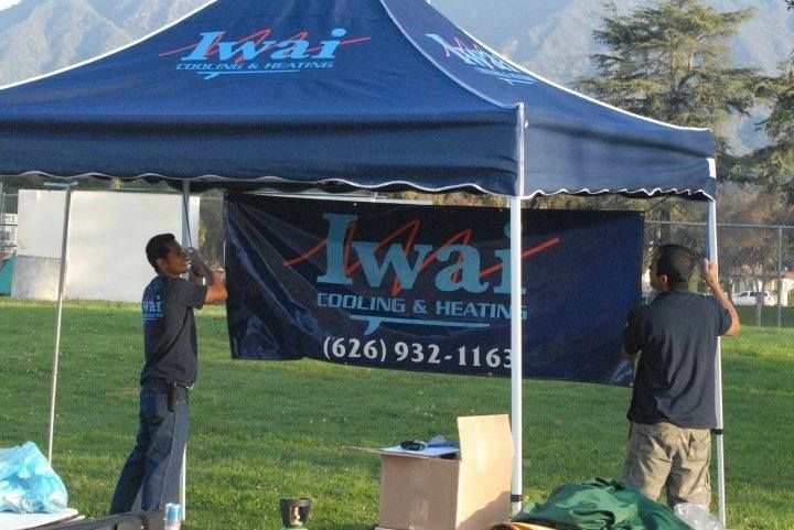 Two men are setting up a tent for iwai cooling and heating
