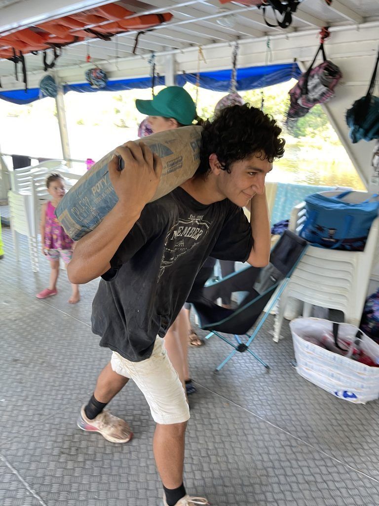 Group of people with hands in a circle, smiling, demonstrating teamwork.