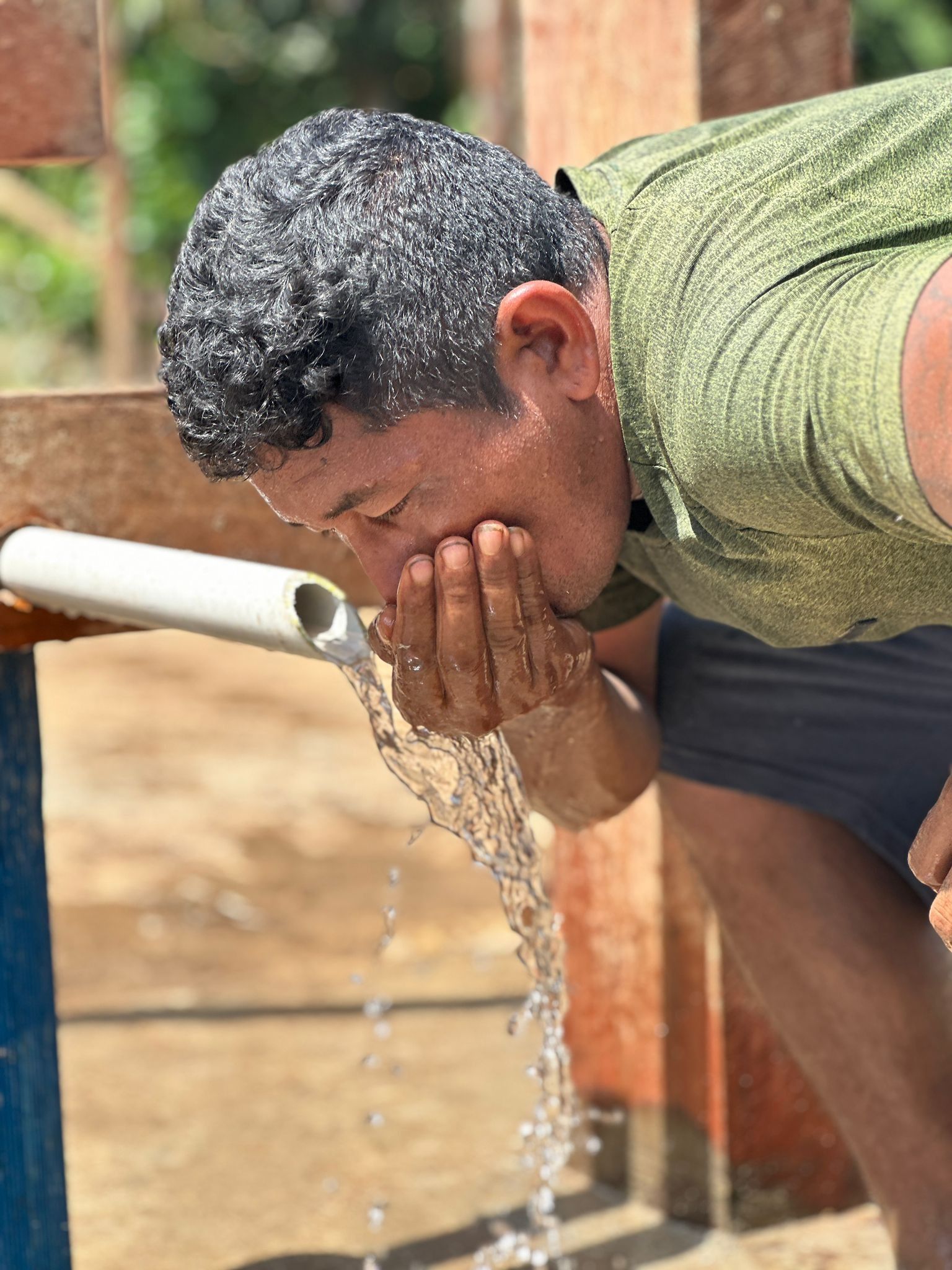 Group of people smiling and talking outdoors, possibly volunteering.
