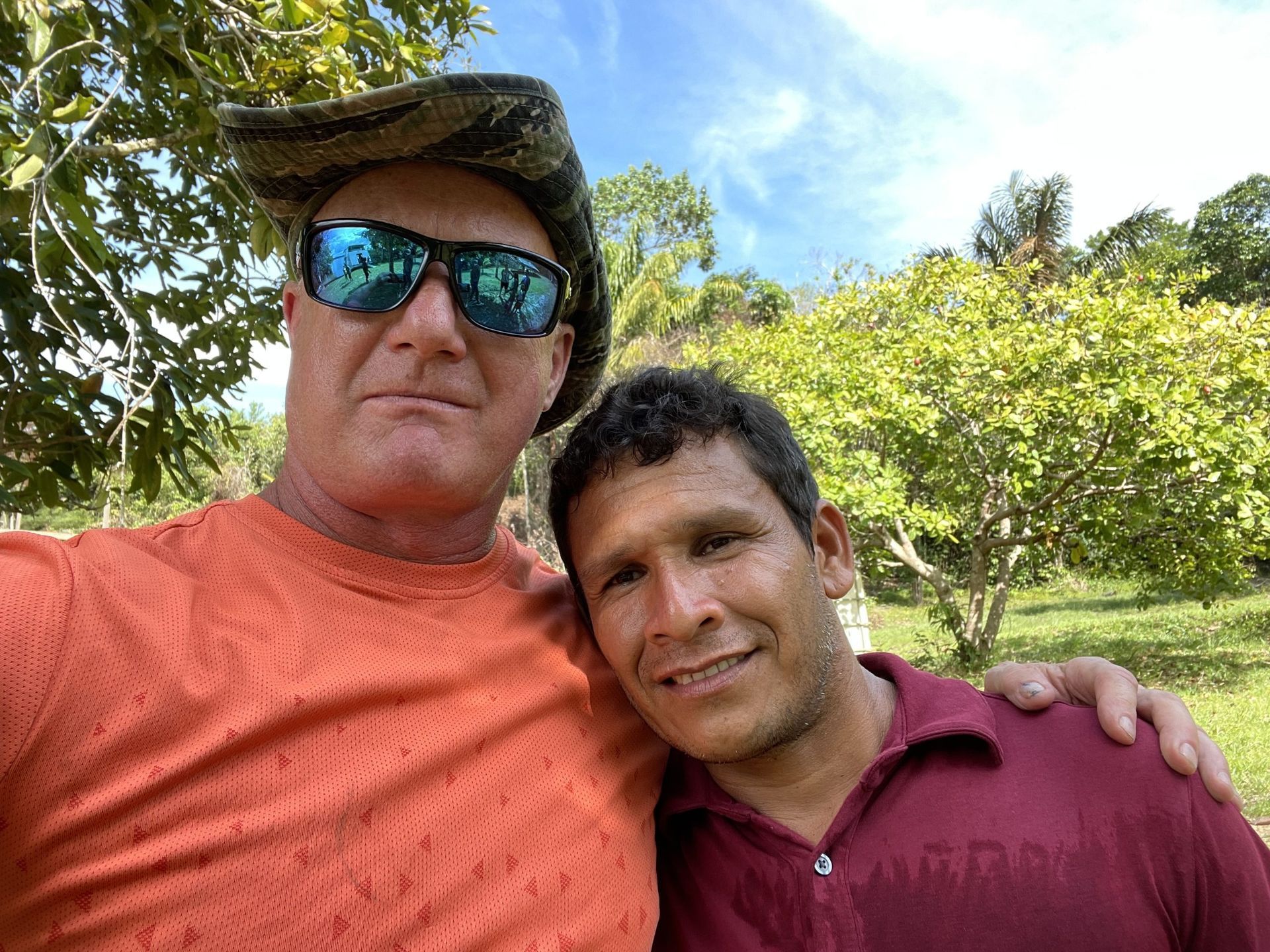 Group of people with hands in a circle, smiling, demonstrating teamwork.