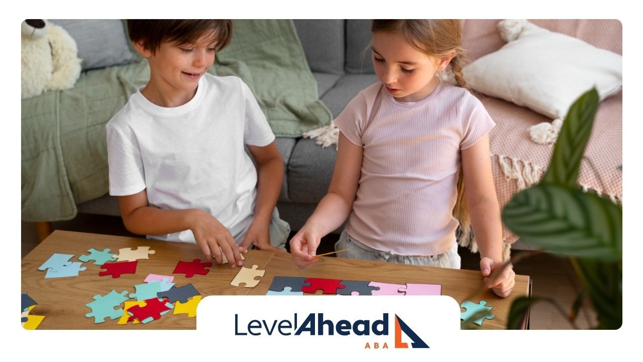 A young boy and a girl are sitting at a table playing with puzzles.