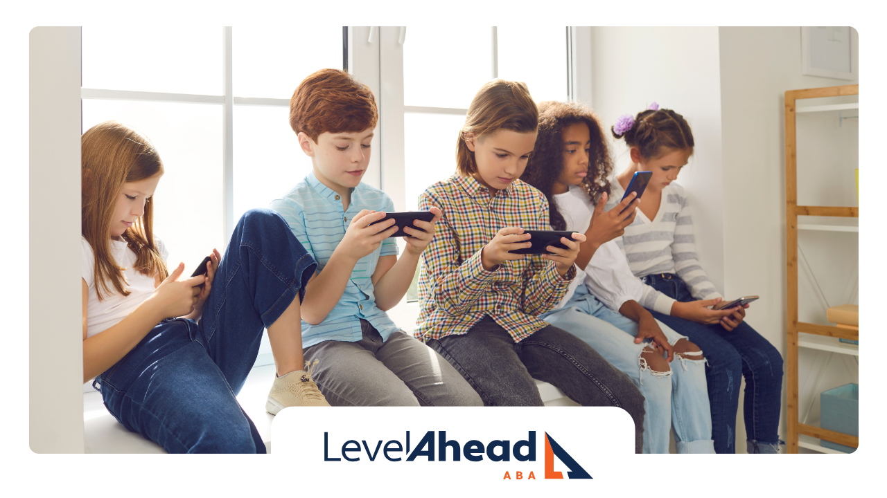 A group of children are standing next to each other looking at their phones.