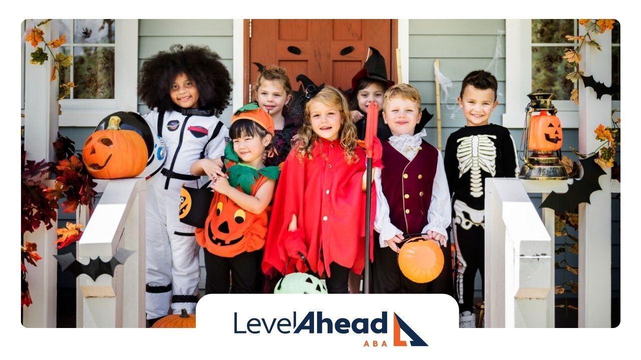 A group of children in halloween costumes are standing on a porch.