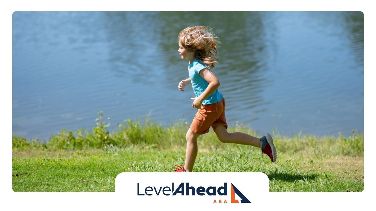 A little girl is running towards a body of water.