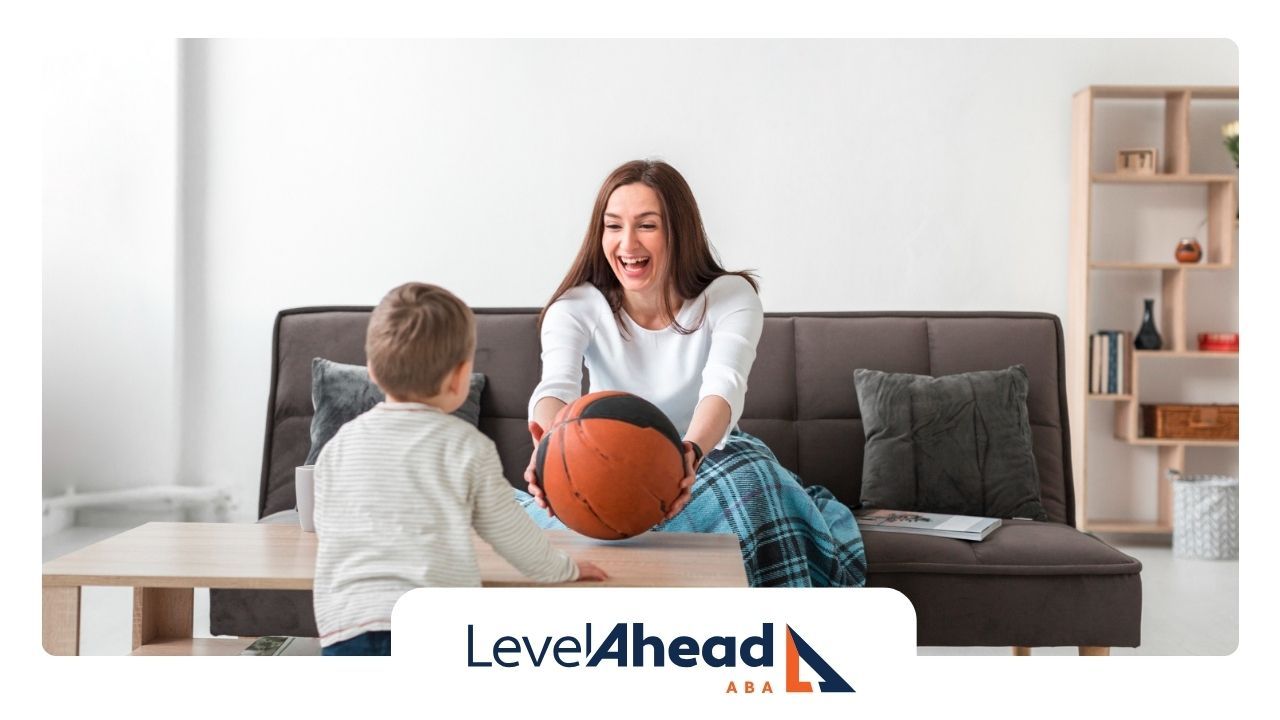 ABCBA and a boy are playing with a basketball on a couch.