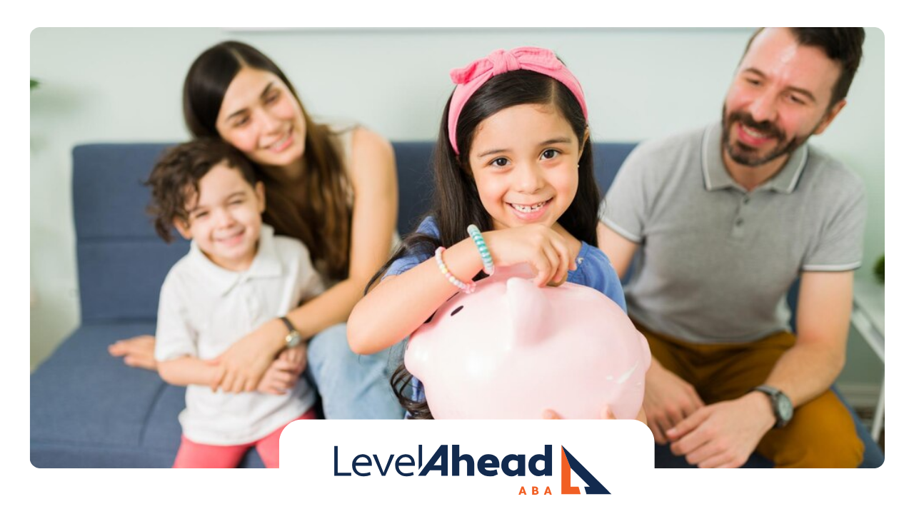 A family sitting together with a little girl putting a coin in her piggy bank