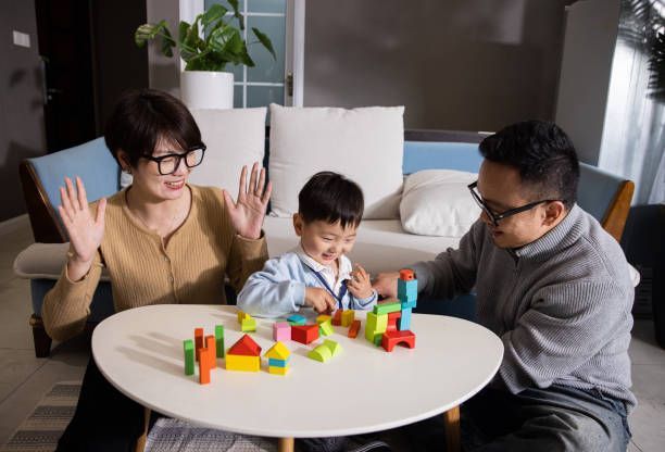 A family sitting at a table playing with wooden blocks