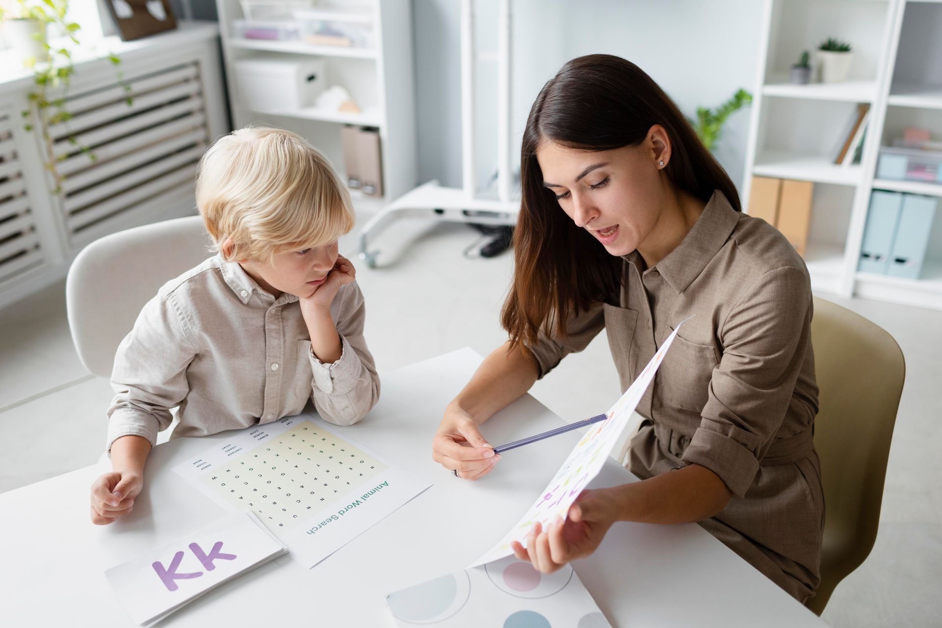 A woman and a little girl sitting at a table painting with watercolors 