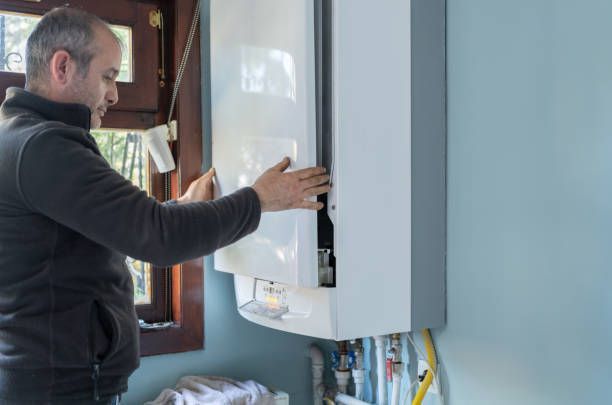 A male technician from R Acres Plumbing performs a water heater installation in Naples, FL