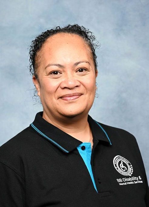 A woman wearing a black and blue polo shirt is smiling for the camera.