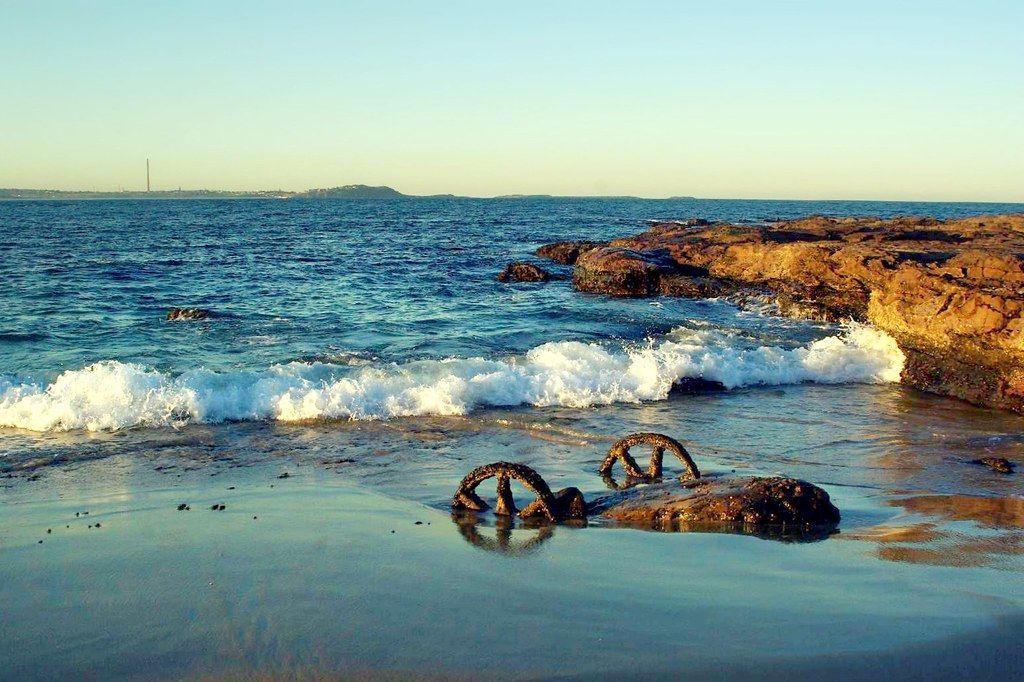 A beach with rocks and waves crashing on it