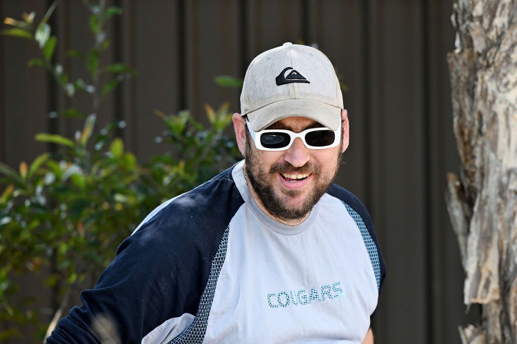 A man wearing sunglasses and a quiksilver hat