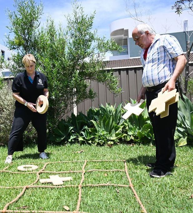 A man and a woman are playing a game in the grass