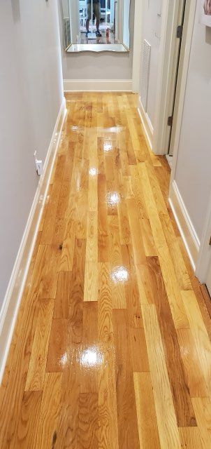A man is measuring a piece of carpet with a tape measure.