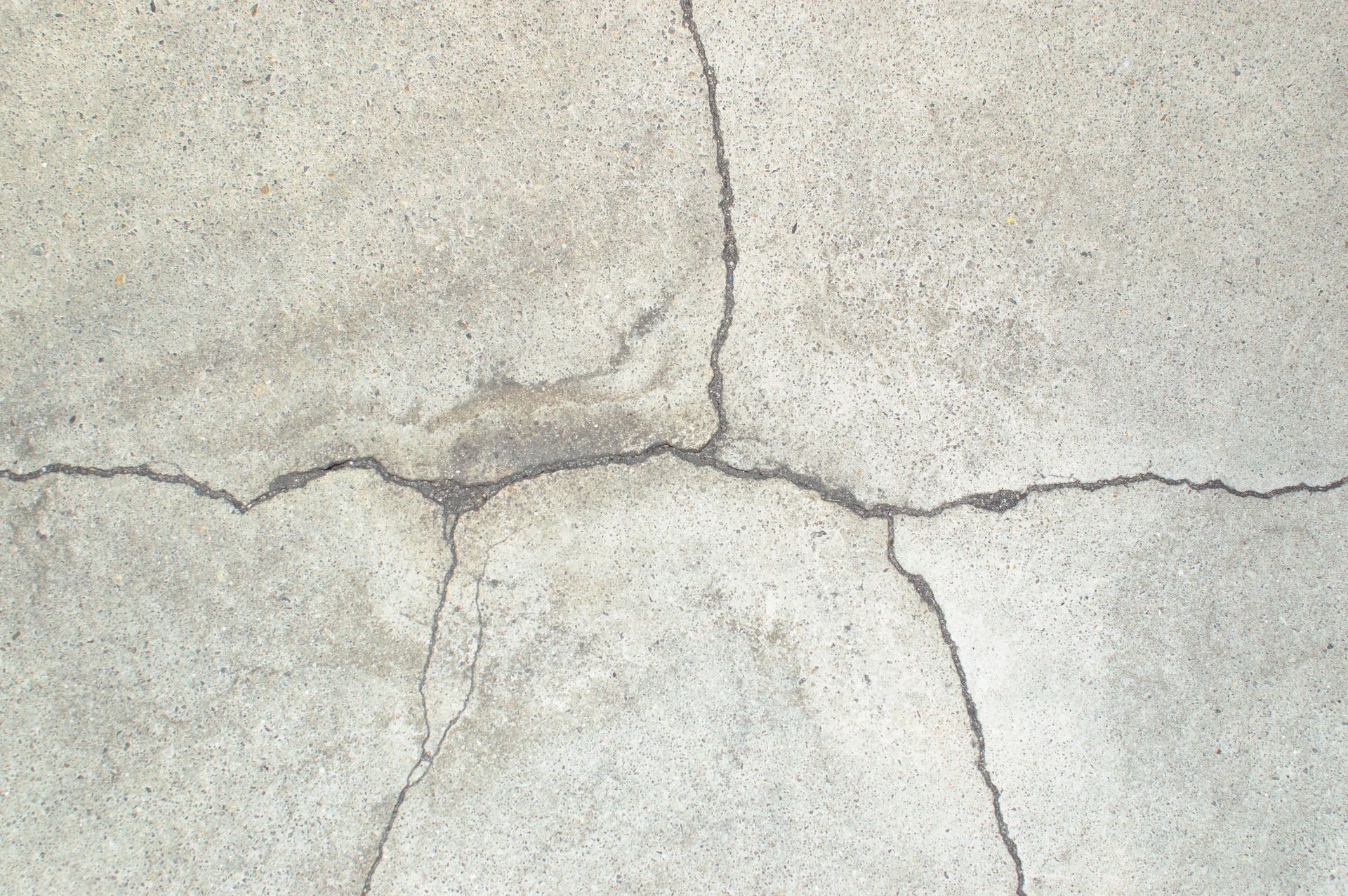 A close up of a cracked concrete surface.