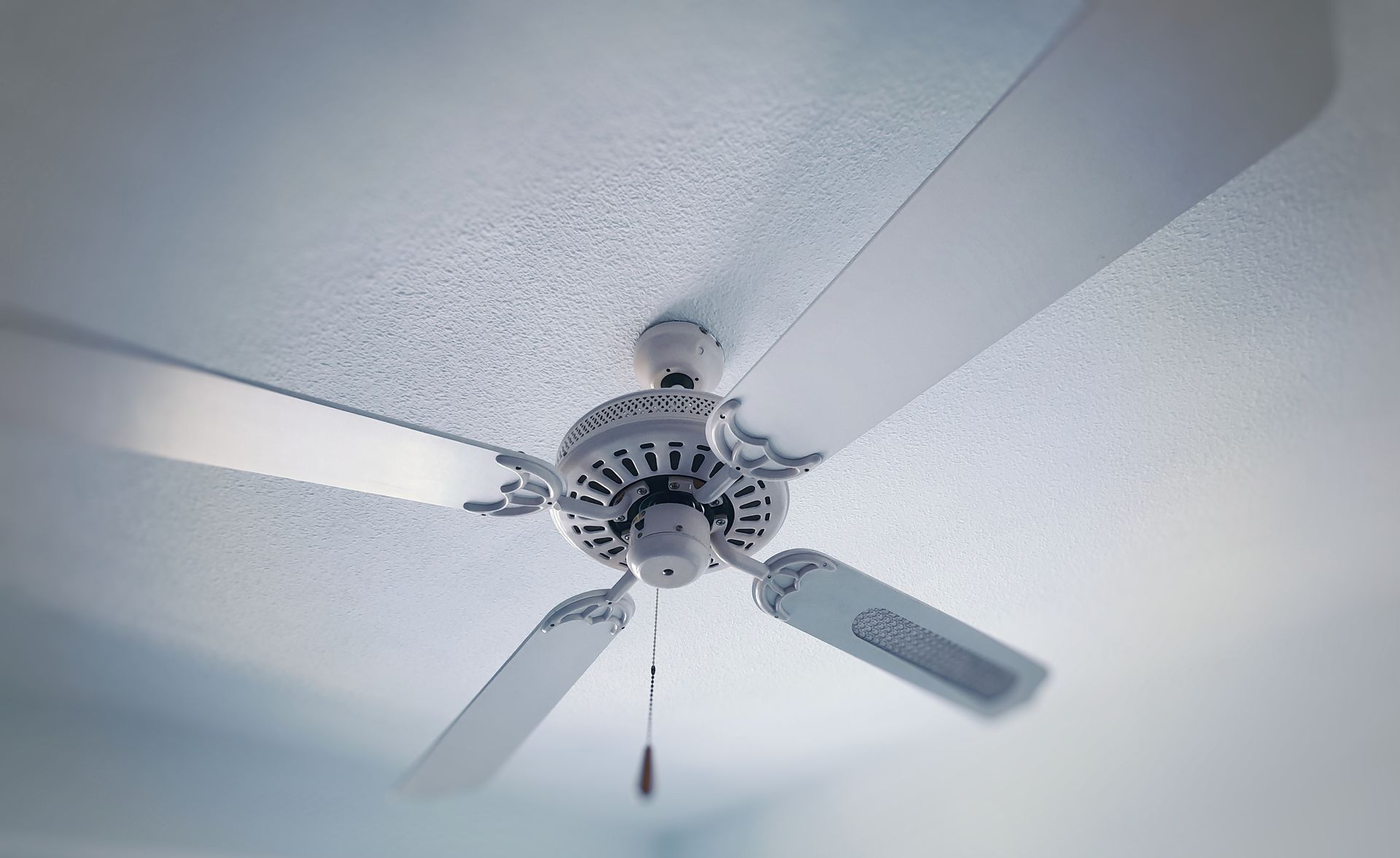 A white ceiling fan is hanging from the ceiling of a room.