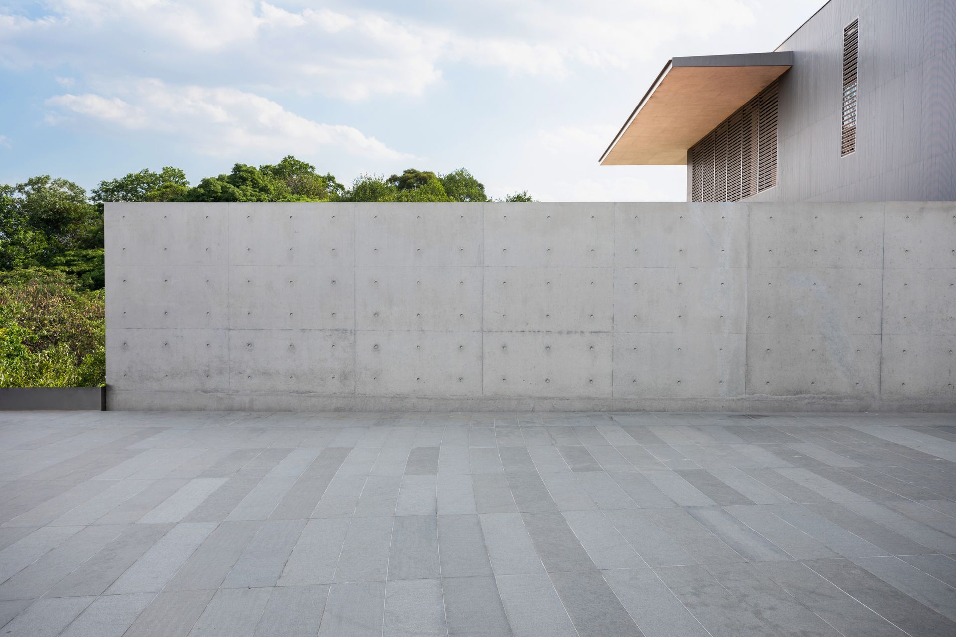 An empty concrete floor in front of a building with a concrete wall.