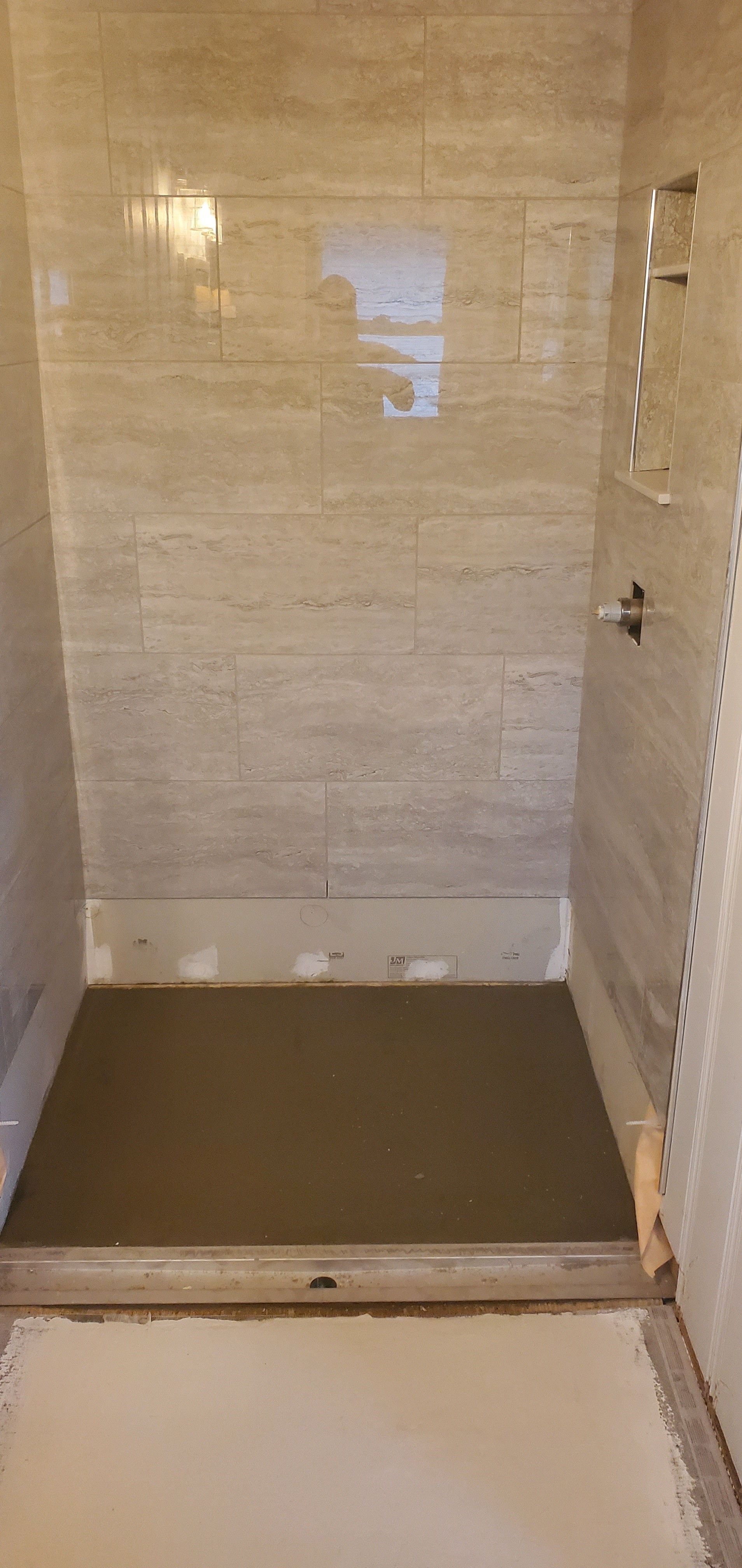 A shower stall is being built in a bathroom.