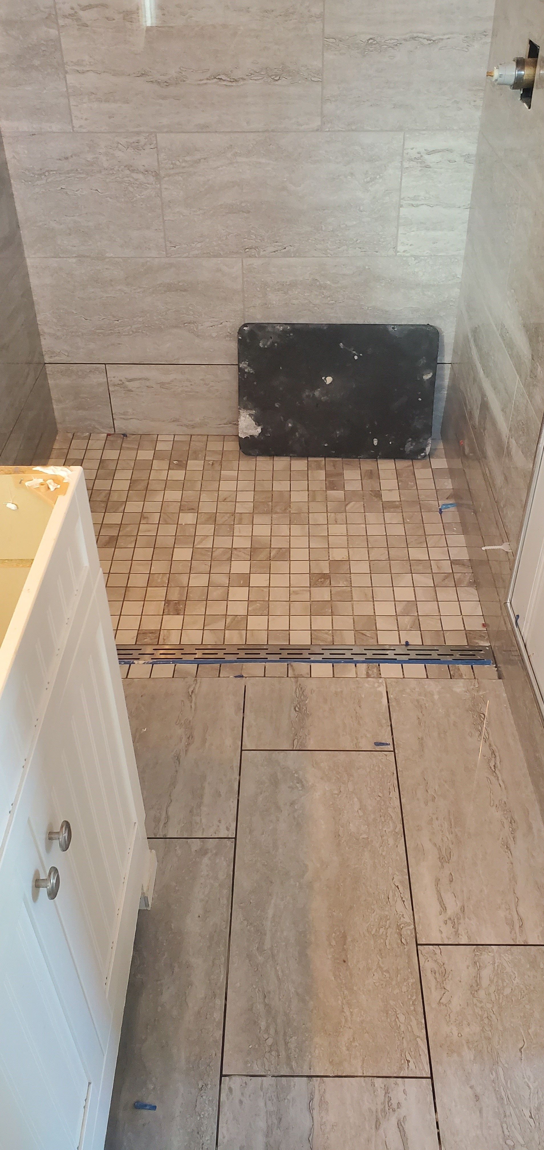 A bathroom with a tiled floor and a sink.