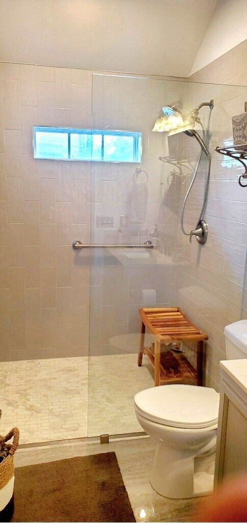 A bathroom with a toilet , sink and walk in shower.