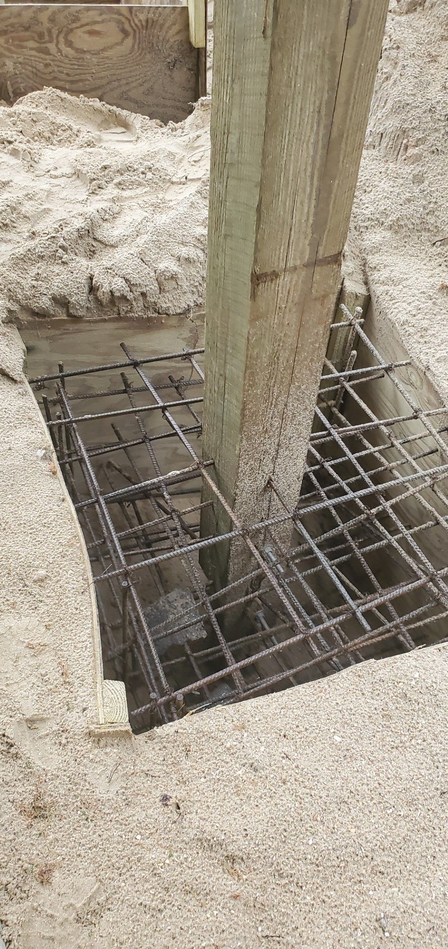 A man is standing on a wooden deck holding a box.
