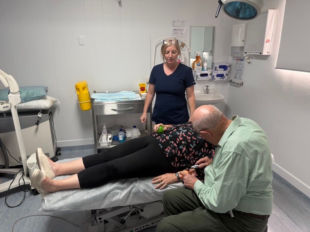 A Group of Women Wearing Pink Breast Cancer Awareness Shirts Are Holding Hands — Health Hub Mackay in Mackay, QLD