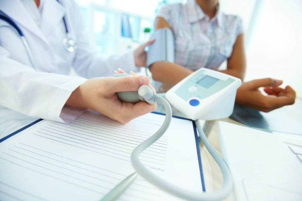 Doctor Checking Blood Pressure Of Woman — Health Hub Mackay in Mackay, QLD