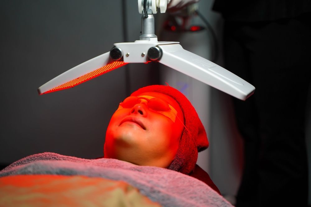 A Red Light Is Shining on A Person 's Face — Health Hub Mackay in Mackay, QLD
