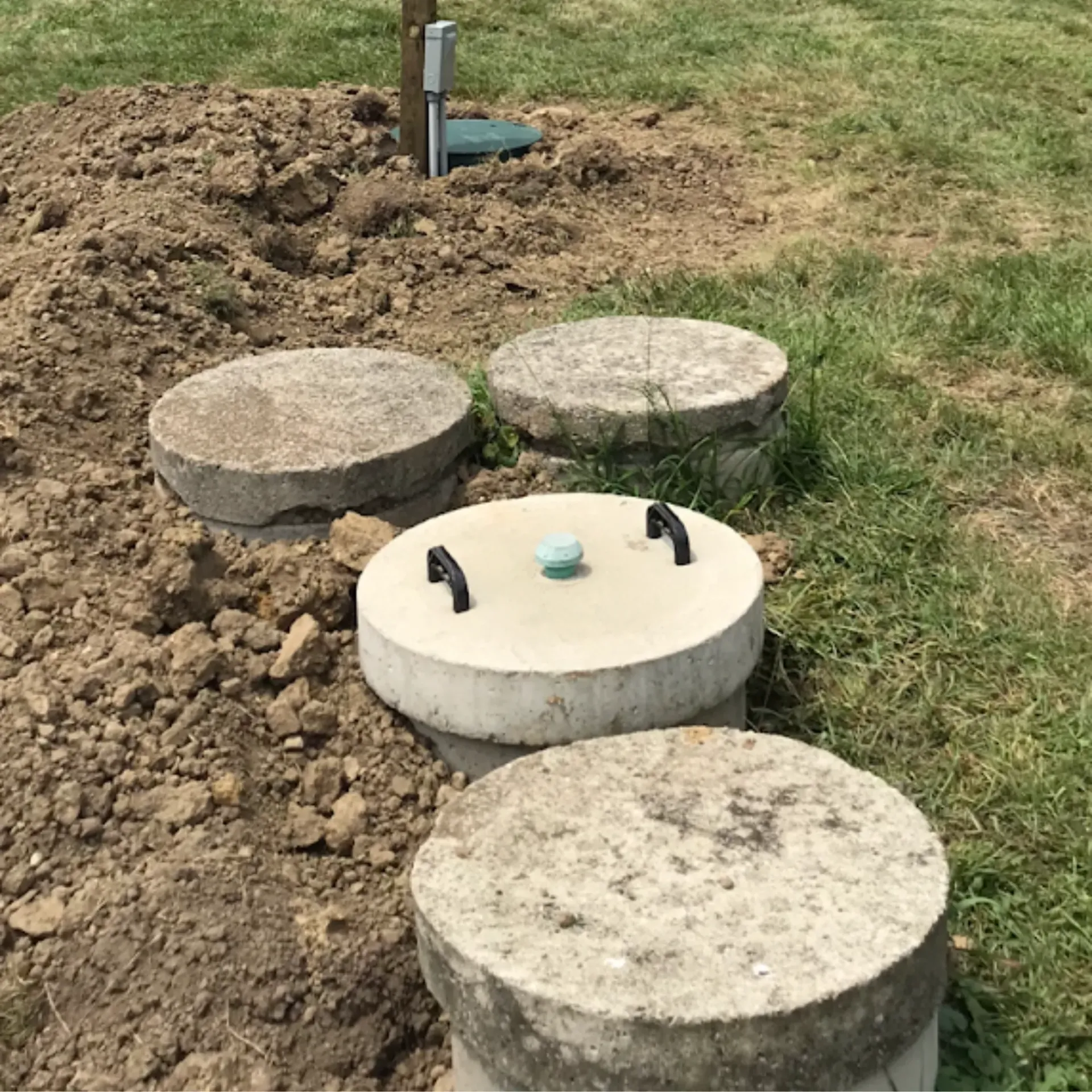 Affordable Waste Services - A group of concrete circles are sitting in the dirt in a field.