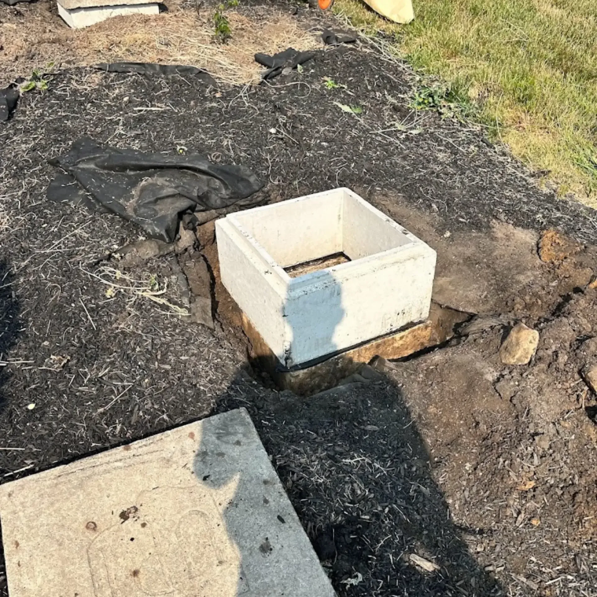 Affordable Waste Services - A concrete block is sitting in the middle of a dirt field.