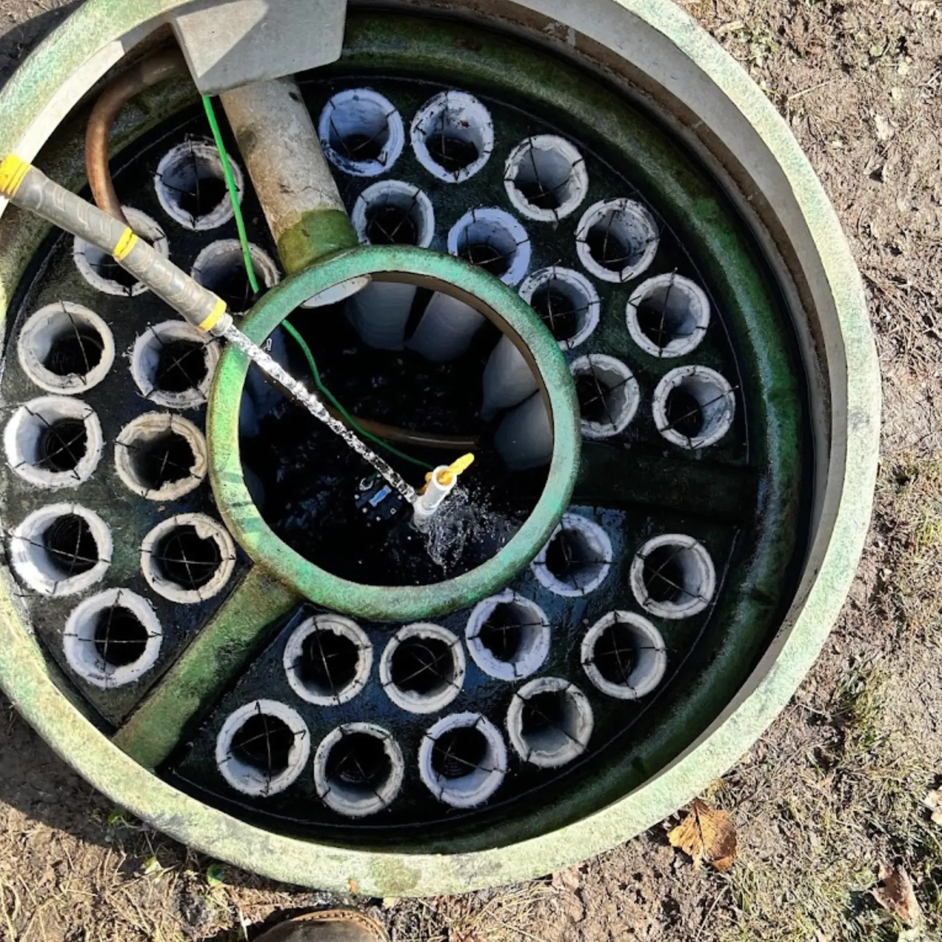 Affordable Waste Services - A hose is being used to clean a septic tank.