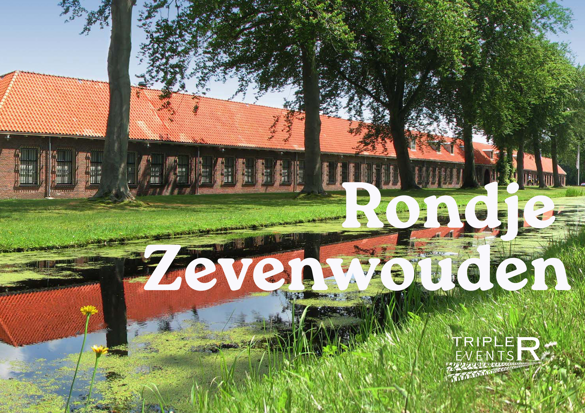 Lang gebouw met rood dak langs een kanaal, met de tekst