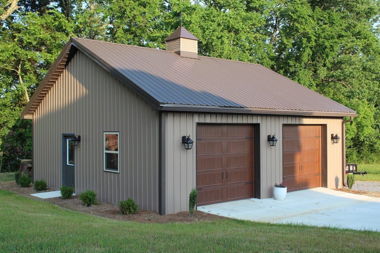 Tan garage with two brown doors and concrete pad