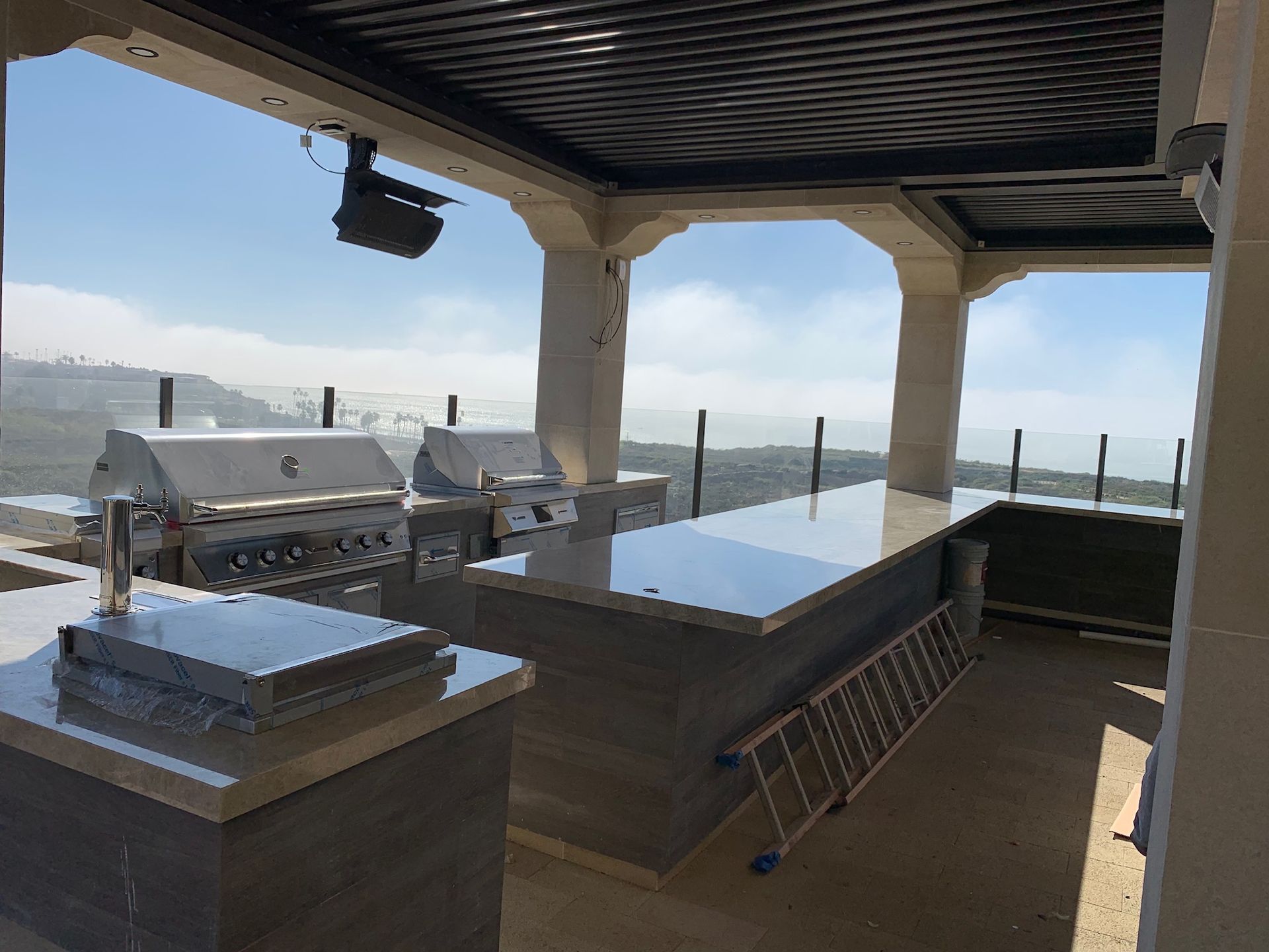 A large outdoor kitchen with a view of the ocean