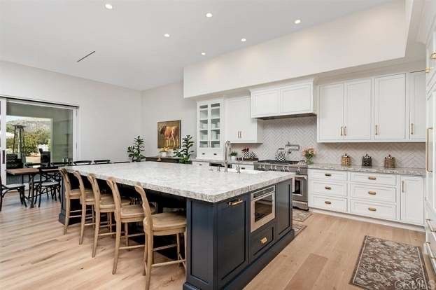 A kitchen with a large island and white cabinets