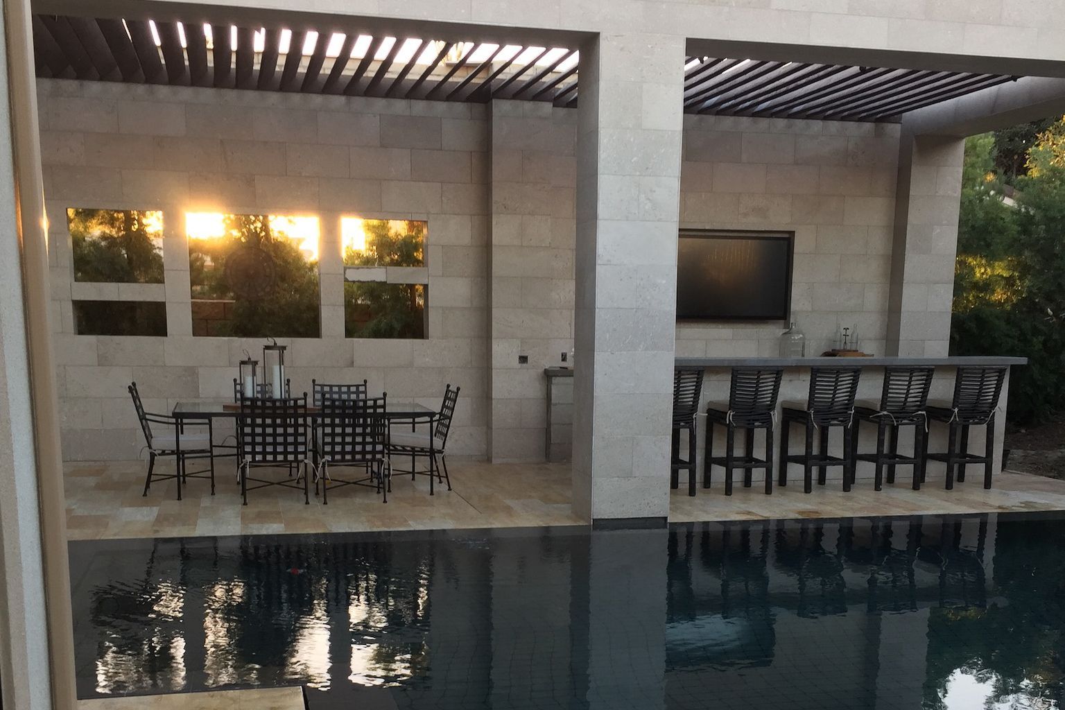 A patio with a table and chairs next to a pool in Vista California