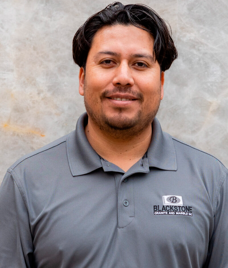 A man wearing a gray shirt with the word blackstone on it