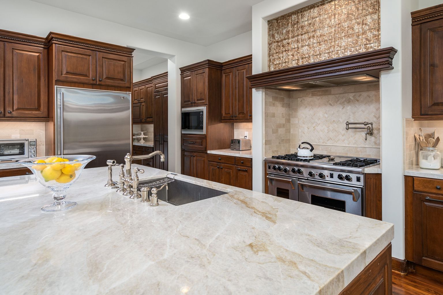 A kitchen with stainless steel appliances , granite counter tops , and wooden cabinets.