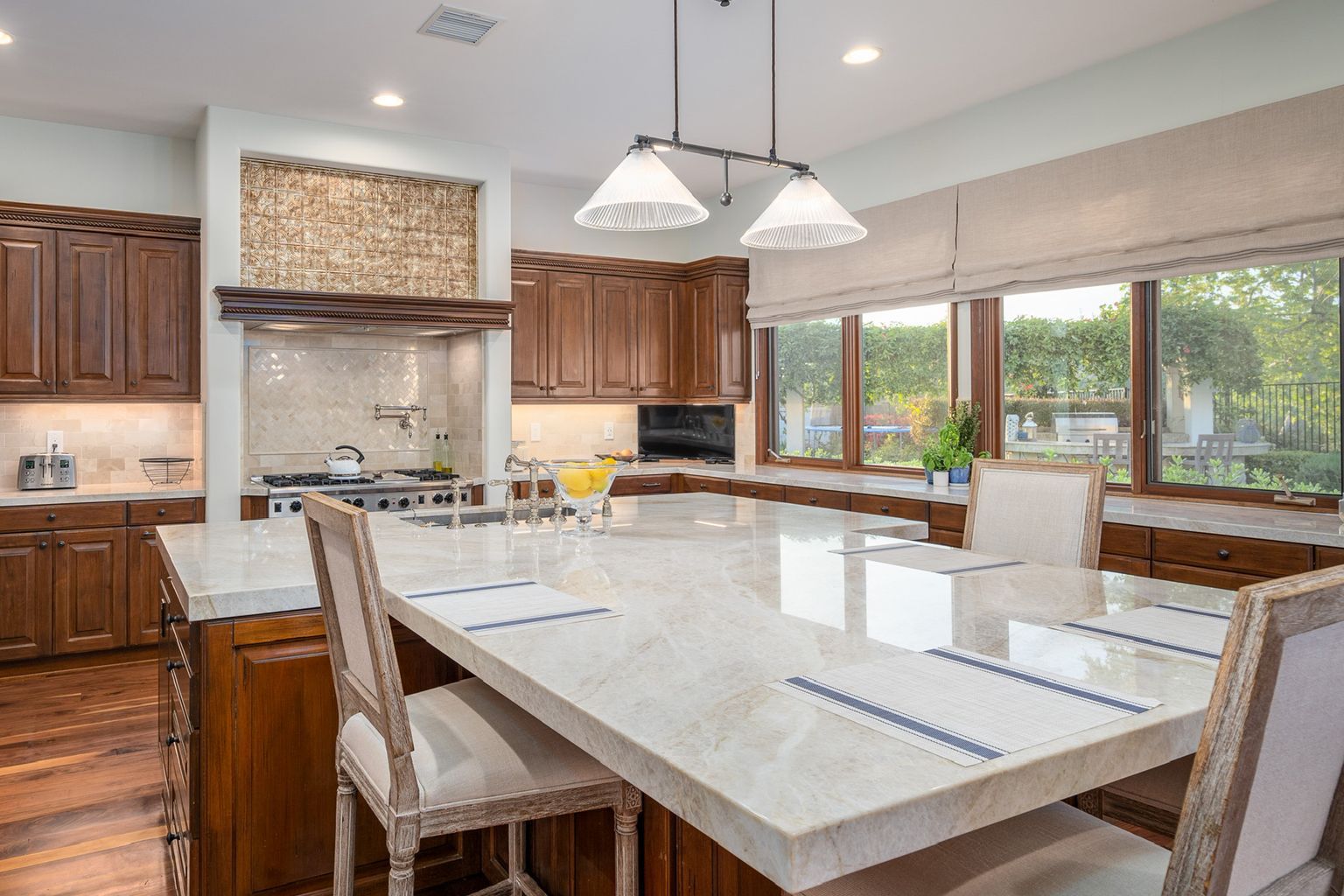 A kitchen with a large table and chairs and a large island.
