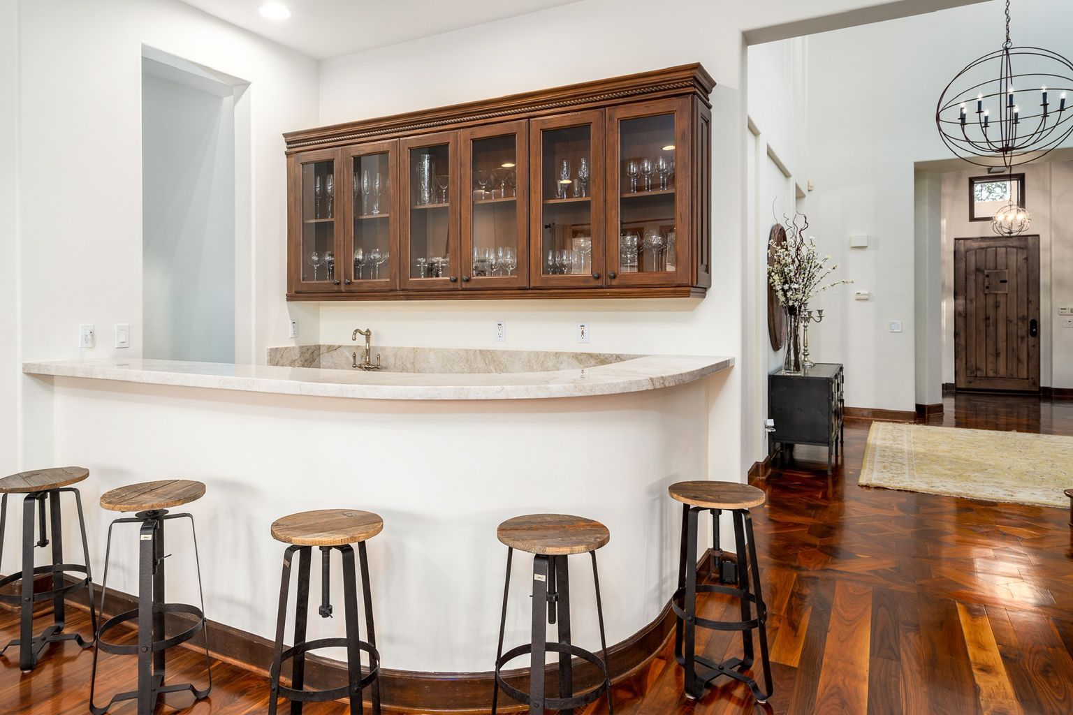 There is a bar with stools in the middle of the room.