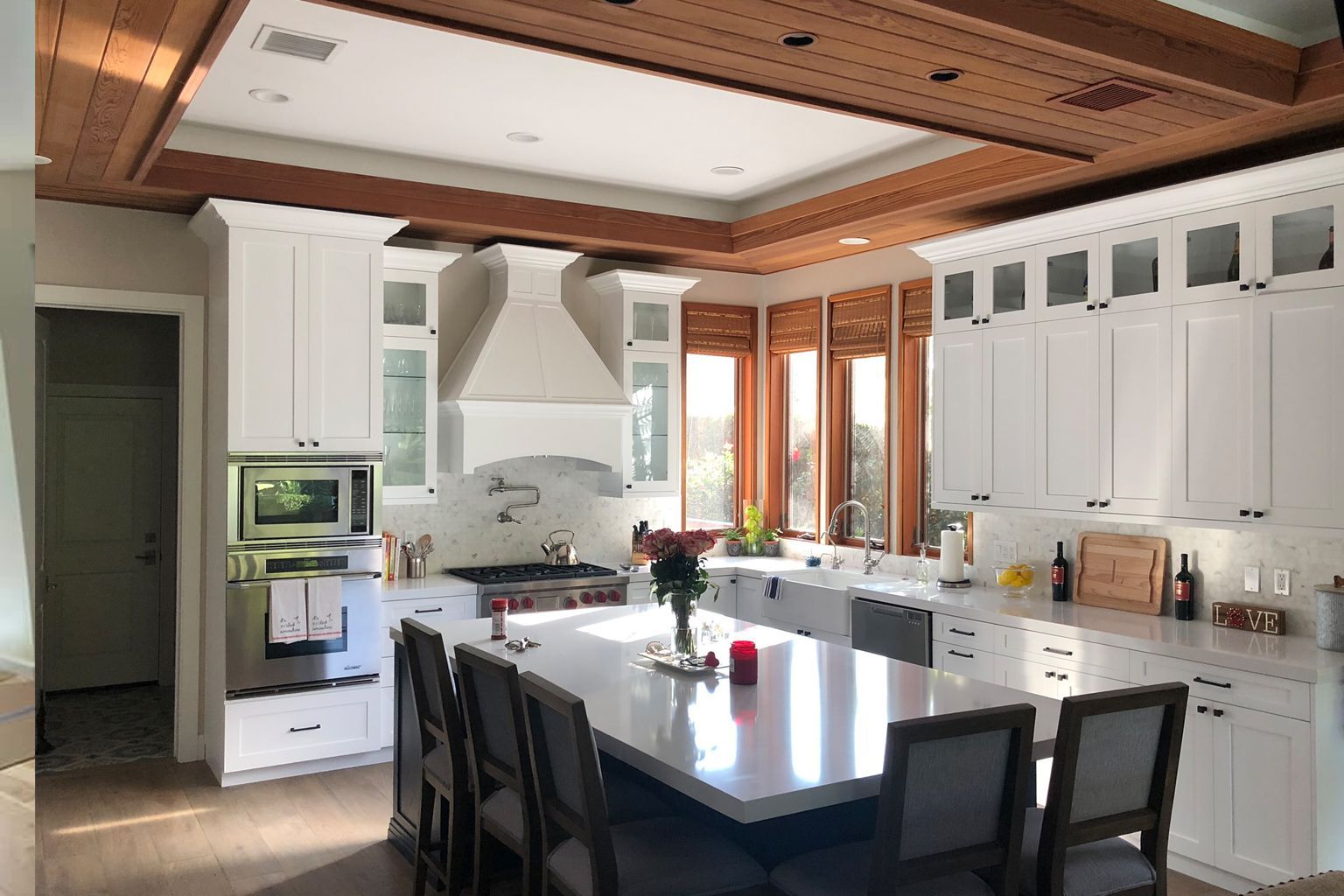 A kitchen with white cabinets and a large island in the middle